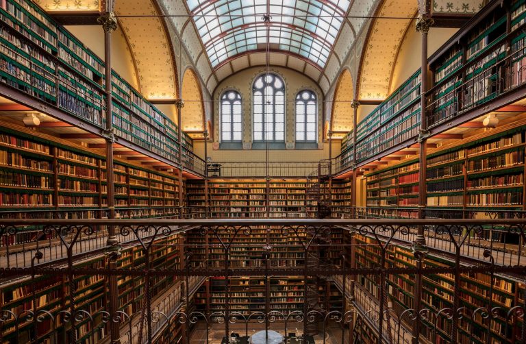 Explore the ornate and historic library interior at Amsterdam's Rijksmuseum, filled with ancient books and architectural beauty.